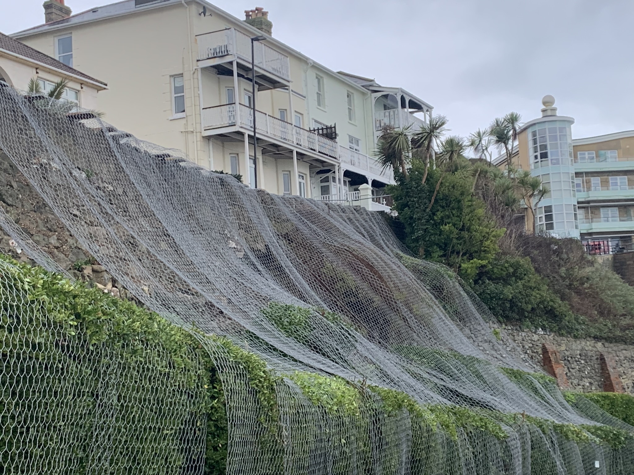 Photo showing terracing at Belgrave Road Ventnor covered by wire netting following the partial collapse of a wall