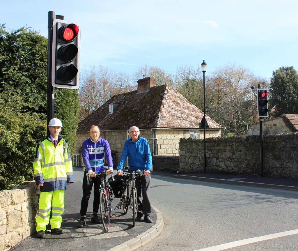 Photo showing cyclists and Island Roads staff member at traffic signals in Shalfleet