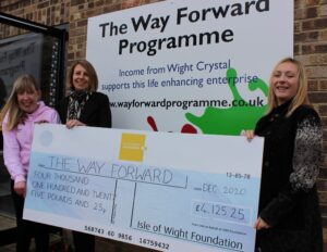 Photo showing Island Roads employee and members of The Way Forward programme holding a large cheque from the Isle of Wight Foundation