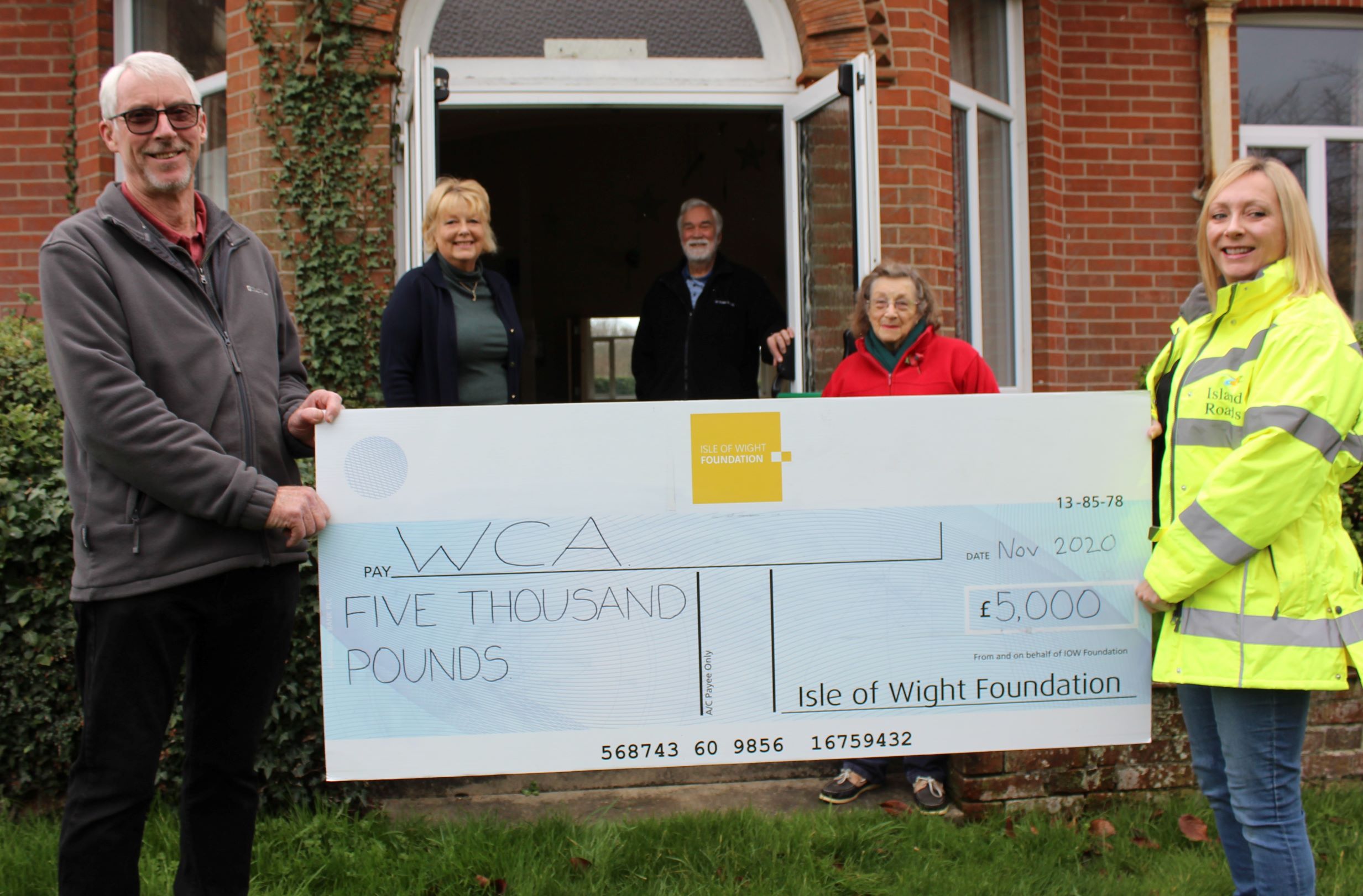 Photo showing Island Roads employee and members of the Whippingham Community Association holding a large cheque from the Isle of Wight Foundation