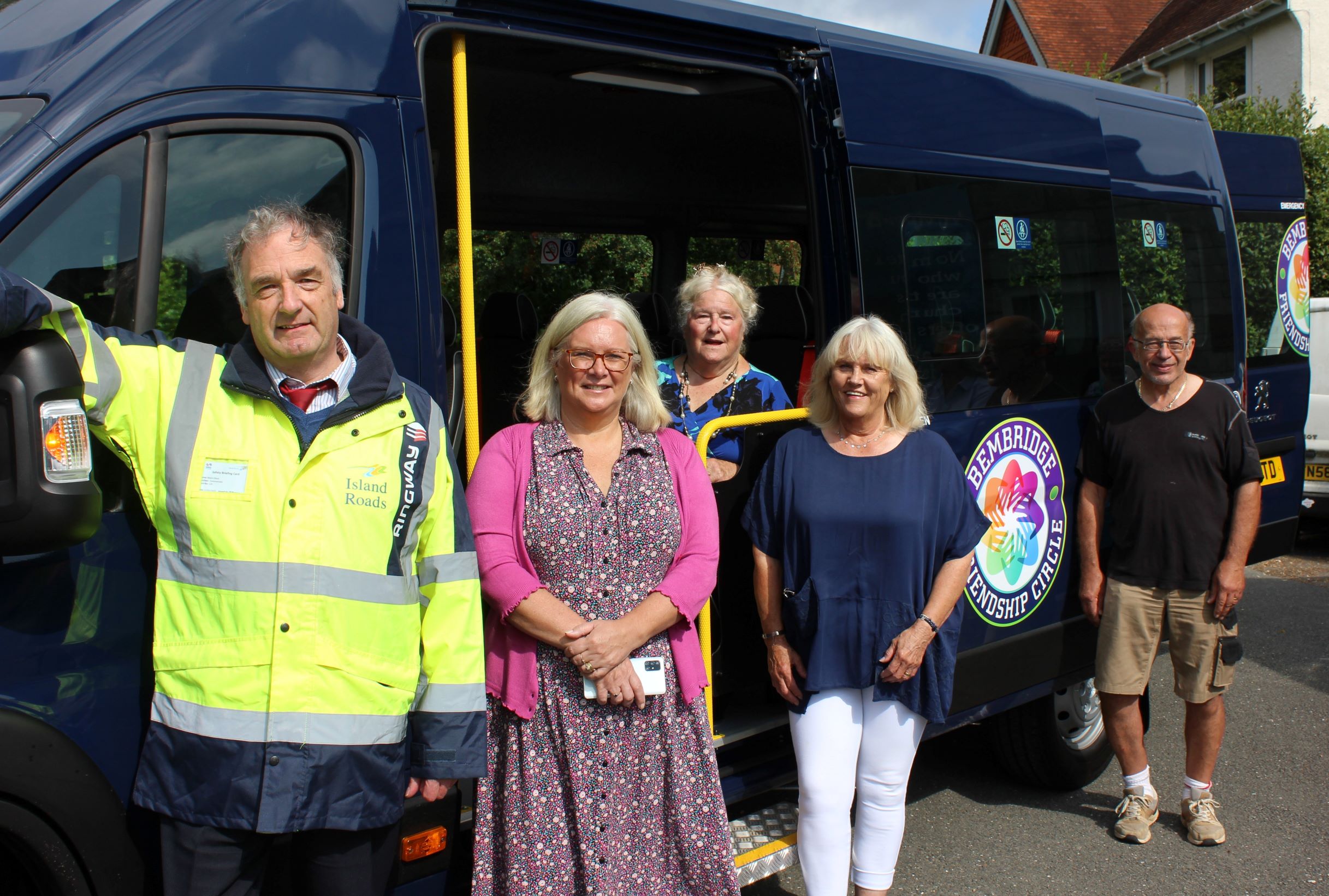 Picture shows volunteers and Island Rads' Mark Eliiott standing by the new bus