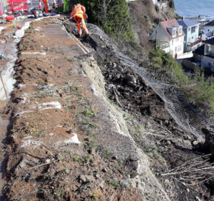 A section of the exposed embankment where the wall collapsed at Belgrave Road, workman in the background hand clearing sections.