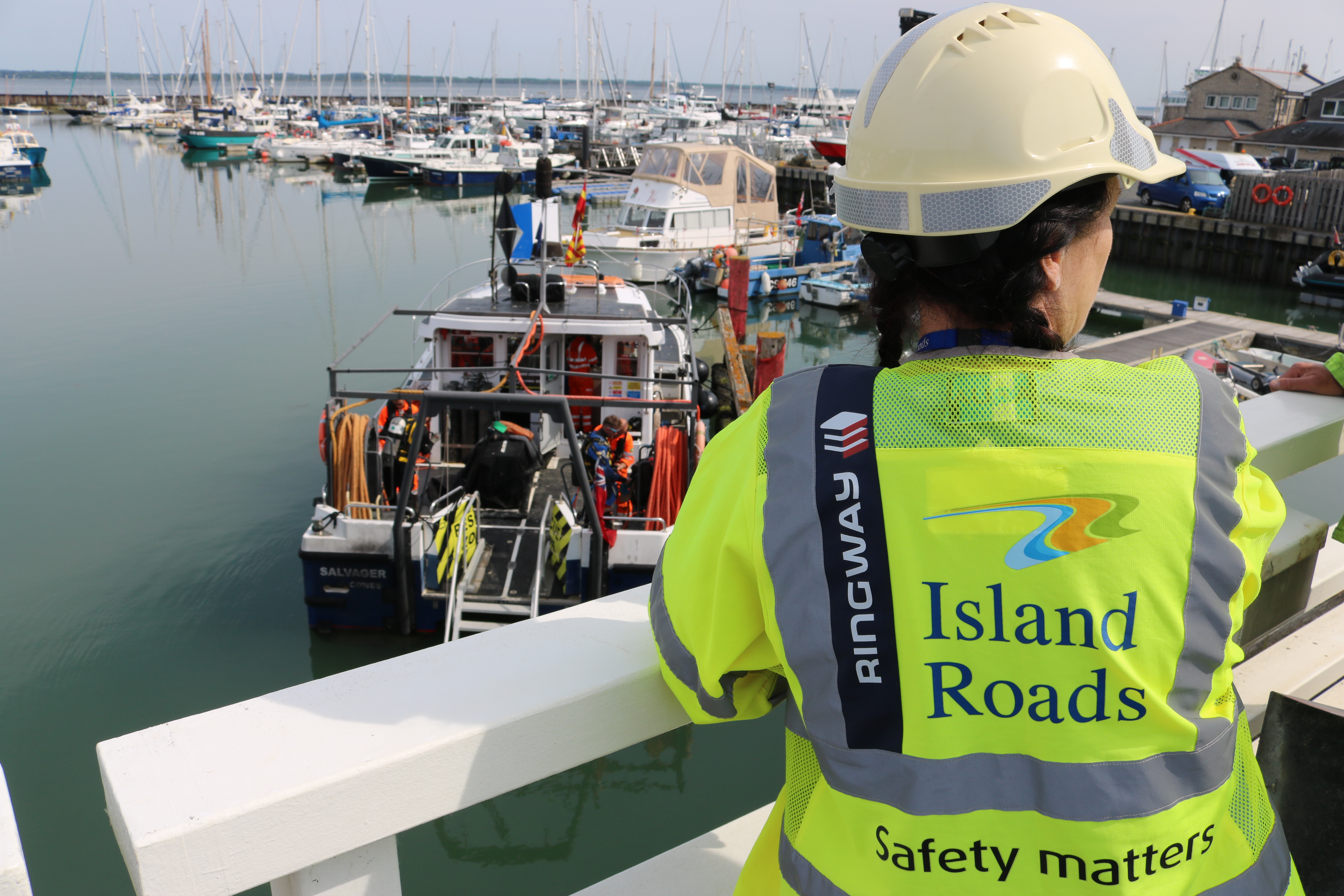 lady in Island Roads work uniform looking at works from the bridge