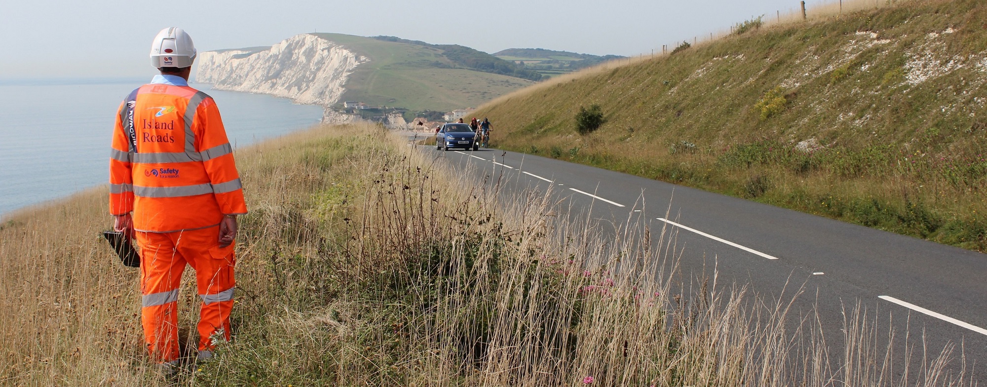 district steward (man) standing by road overlooking Freshwater Bay