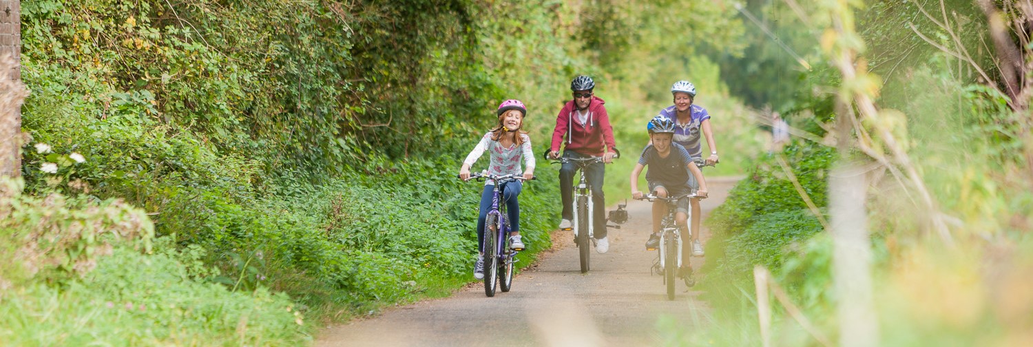 family of four cycling along a rural cycle track