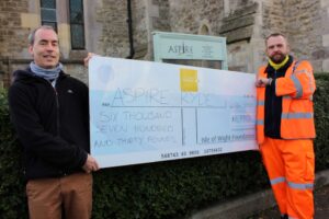 Photo showing two people, one from Island Roads, one from Aspire holding a giant cheque