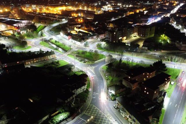 Ariel photo taken at night showing new LED white lighting around Coppins Bridge with old orange lights of prison estate visible in the background
