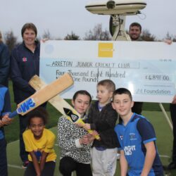 group of people holding a large cheque for £4,891 for Arreton Junior Cricket Club, children holding cricket bats in foreground