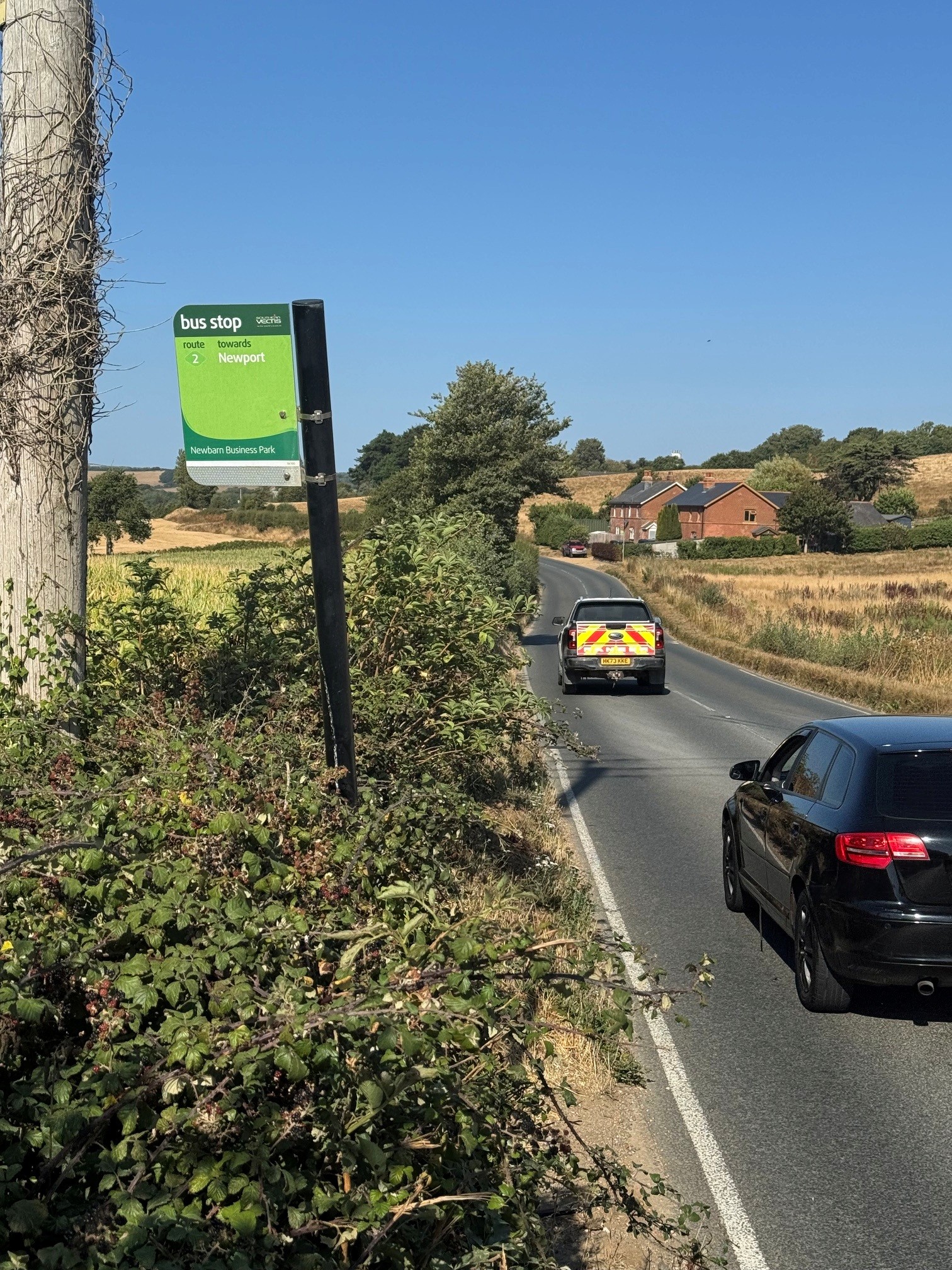 bus stop next to busy road with cars passing
